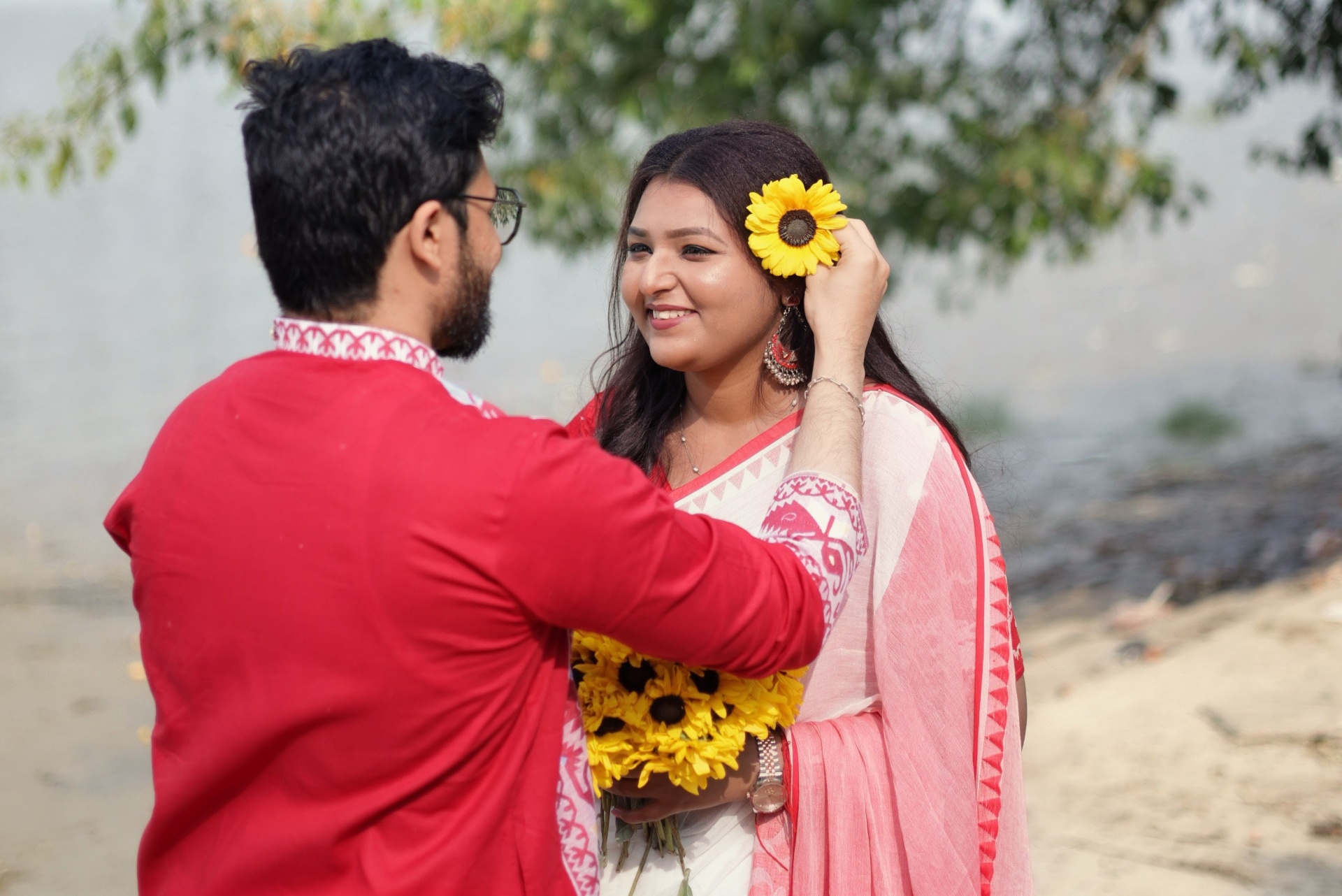 Groom placing a sunflower in bride's hair